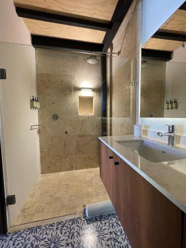 a bathroom with a sink and a glass shower at Las Lupitas Hotel Boutique in Campeche