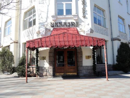 un edificio con un toldo rojo delante de él en Grand Hotel Ukraine, en Dnipro