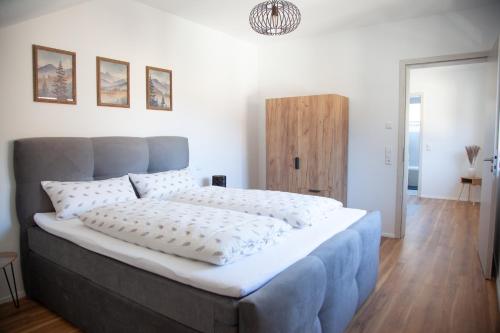 a bedroom with a large bed with white sheets at Auszeit im Weindorf in Kappelrodeck