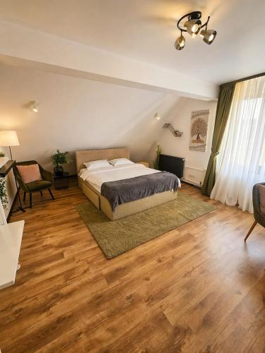a bedroom with a bed and a table and a chair at Pensiunea Relax in Curtea de Argeş