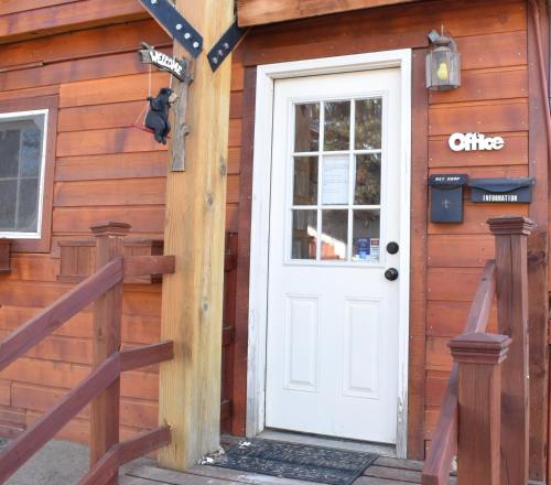 a white door on the side of a wooden cabin at Colorado Cottages in Estes Park