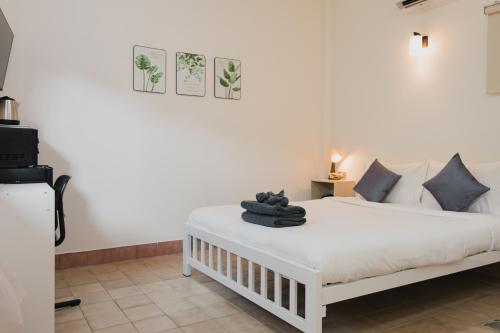 a bedroom with a white bed with towels on it at Kavana Kata Residence in Phuket