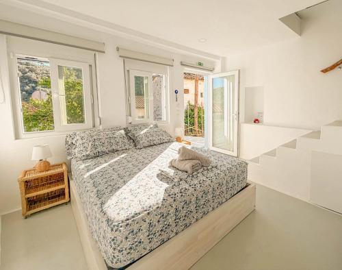 a bedroom with a bed in a room with windows at Casa Calliope in Playiá