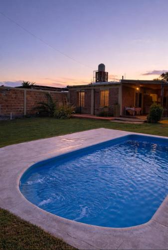 a large blue swimming pool in front of a house at Osvaldo Day Cabin with Pool in Albardón