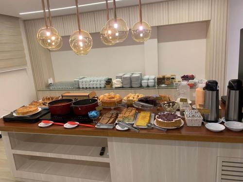 a counter with many different types of food on it at GoldMen Select Maringá in Maringá