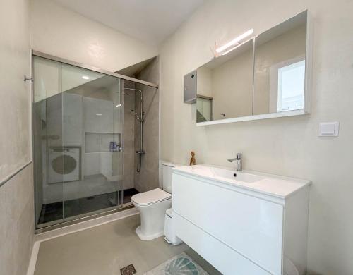a bathroom with a toilet and a sink and a shower at Casa Calliope in Playiá