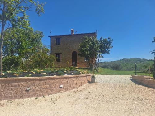 a house with a brick wall in front of a yard at casa Bel Posto in San Ginesio