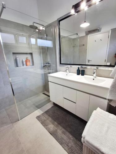 a bathroom with a white sink and a shower at Bay View Apartment in Funchal