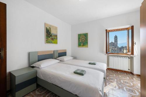 a bedroom with two beds and a window at Ca' Due Cuori in Torri del Benaco