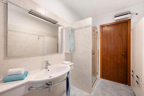 a bathroom with a sink and a mirror and a shower at Ca' Due Cuori in Torri del Benaco