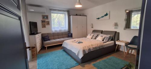 a bedroom with a bed and a couch at Kékbazalt Vendégház in Badacsonytomaj