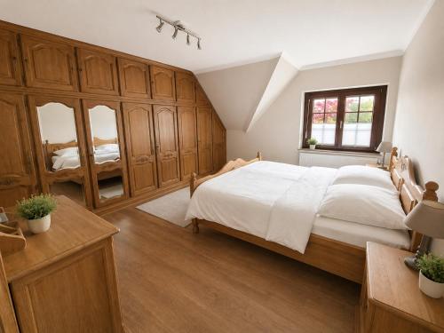 a bedroom with a large bed and wooden cabinets at Sweet&City HOUSE in Saint-Vith