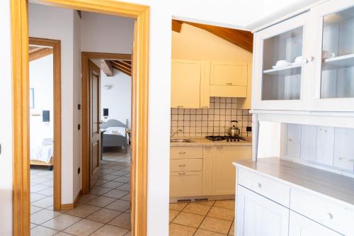 two views of a kitchen with white cabinets at Residence Casa Gardola, GTSGroup in Tignale