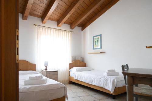 a bedroom with two beds and a window at Residence Casa Gardola, GTSGroup in Tignale