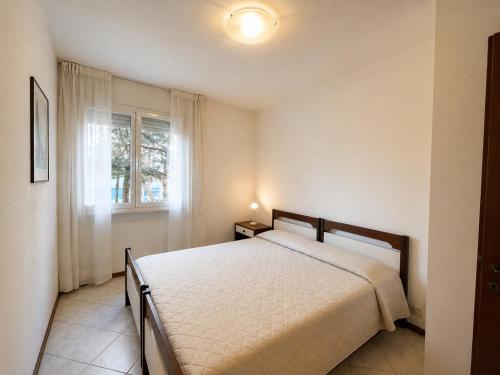 a bedroom with a bed and a window at Appartamento Eunoia I TerraceParking&AC in Lignano Sabbiadoro