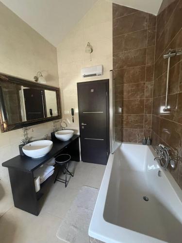 a bathroom with a tub and two sinks and a bath tub at My place Čiovo holiday house in Žedno