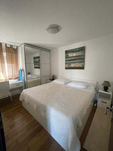 a bedroom with a white bed and a bathroom at My place Čiovo holiday house in Žedno