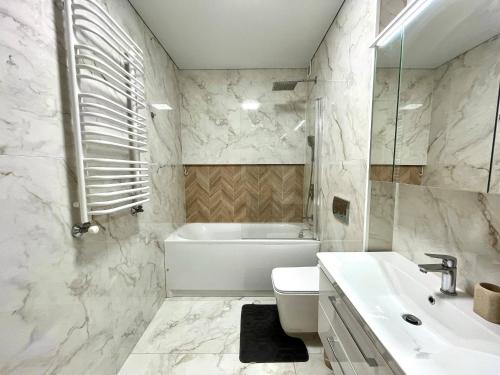 a bathroom with a sink and a toilet and a tub at Voloshyna Central Loft in Ivano-Frankivsk