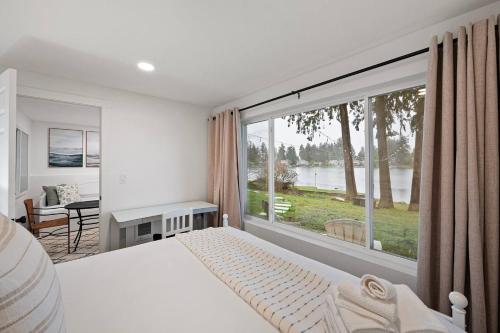 a bedroom with a bed and a large window at Seatac Lake Cottage A2 in SeaTac