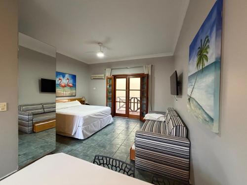 a hotel room with a bed and a chair at Ilha Flat Hotel 4201 in Ilhabela