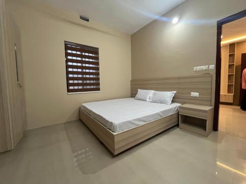 a small bedroom with a bed and a window at S S Apartment in Kannur