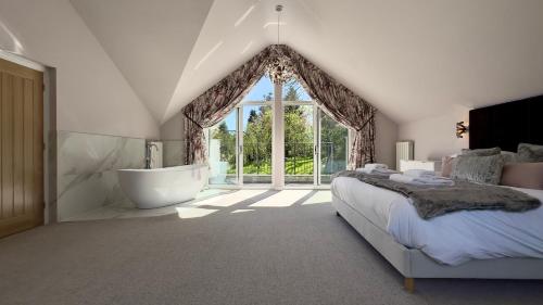 a bedroom with a bed and a tub and a window at Fells in Chapel Stile
