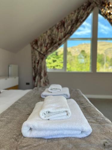 a group of towels sitting on a bed with a window at Fells in Chapel Stile