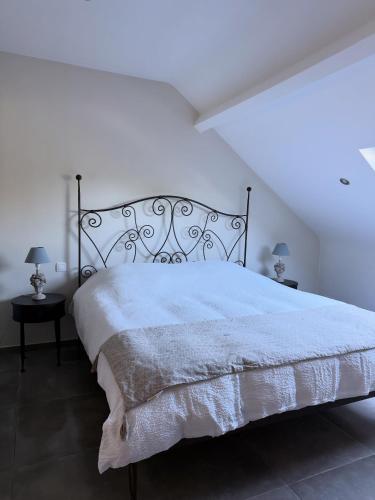 a bedroom with a large bed with a white comforter at La Parenthèse des Charmes in Andenne