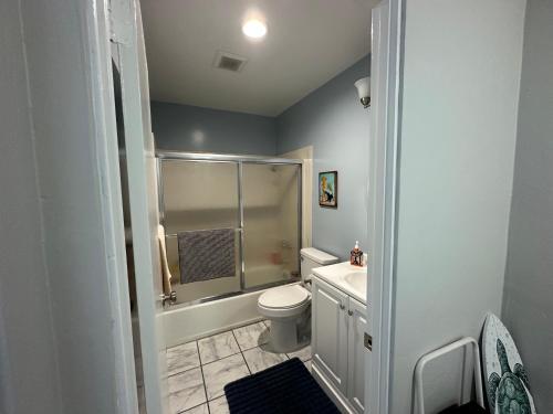 a bathroom with a shower and a toilet and a sink at Surfer's Bungalow in San Diego