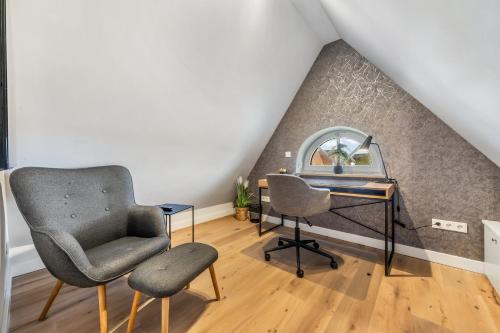 a room with a desk and a chair and a table at Strandgut Wohnung 7 in Wenningstedt