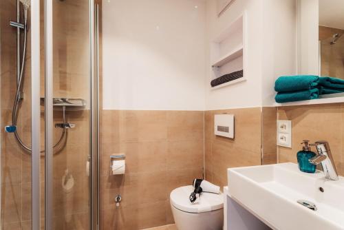 a bathroom with a shower and a toilet and a sink at MiraBlau Braunlage in Braunlage