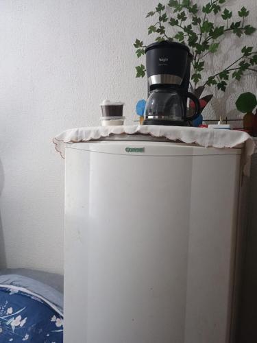 a coffee maker on top of a white refrigerator at Refugio das Laranjeiras Hospedagem in Piraí