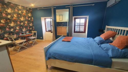 a blue bedroom with a bed and a table at Irie Vibes in Bourganeuf