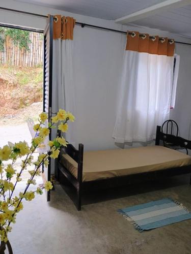 a bedroom with a bed and a window at Refugio das Laranjeiras Hospedagem in Piraí