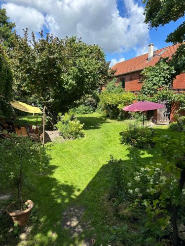 a garden with a green lawn and an umbrella at Sommerhof im Havelland in Nennhausen