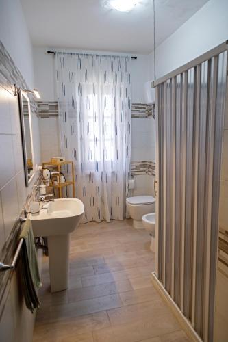 a bathroom with two sinks and a toilet and a shower at Gli agrumi di Nonna Peppina - Appartamento Limoni in Mondragone