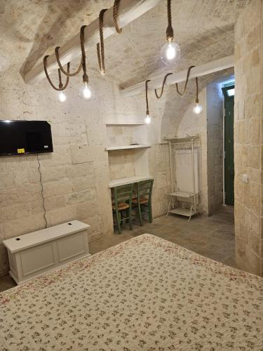 a room with a bed and a table and a tv at Stanza29 in Martina Franca