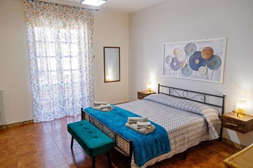 a bedroom with a bed with a blue blanket at Gli agrumi di Nonna Peppina - Appartamento Limoni in Mondragone