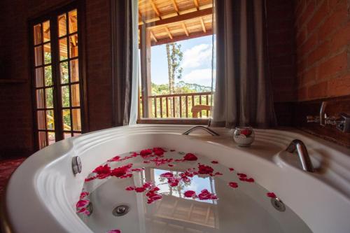 a bath tub with flowers on it in a bathroom at Pousada Recanto do Pico in Santo Antônio do Pinhal