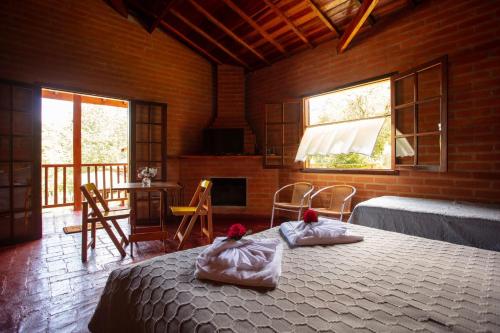a bedroom with a bed in a room with windows at Pousada Recanto do Pico in Santo Antônio do Pinhal