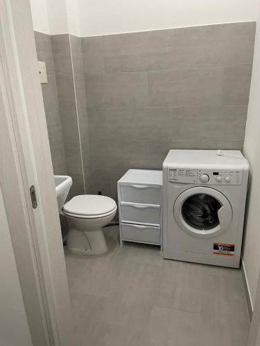 a bathroom with a washing machine and a toilet at Domus de Silvi in Silvi Marina