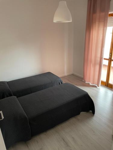 a black bed in a room with a window at Domus de Silvi in Silvi Marina
