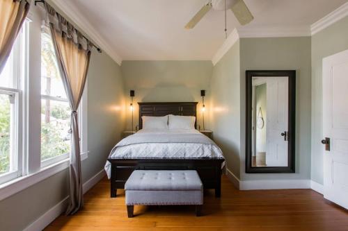 a bedroom with a bed and a mirror and a stool at Iconic Modern Farmhouse in San Luis Obispo
