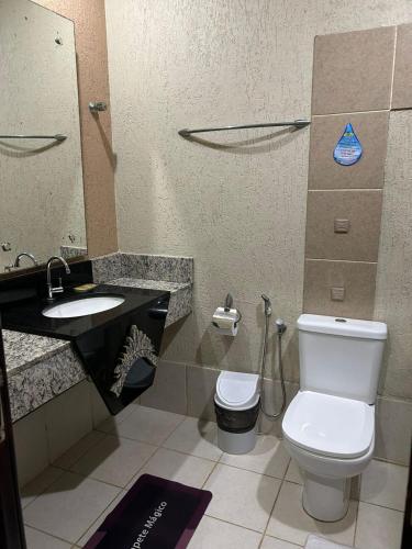 a bathroom with a toilet and a sink at Samaúma Park Hotel in Barcarena