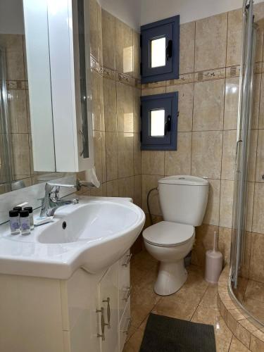 a bathroom with a white sink and a toilet at Kaloula's home in Keramoto