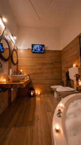 a bathroom with three sinks and a tv on the wall at Suite Room Con Vasca Idromassaggio in Aversa