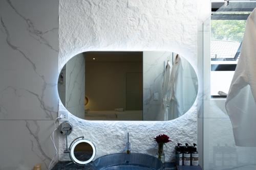 a bathroom with a mirror and a blue sink at 18 On OniX - World Class in Four Ways