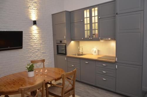 uma cozinha com uma mesa de madeira e uma sala de jantar em Apartment Into3City Old Town Gdansk em Gdansk