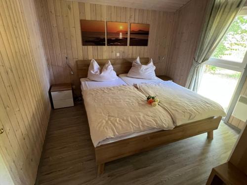 a bedroom with a bed with white sheets and a window at Seeschwalbe 240 in Mirow