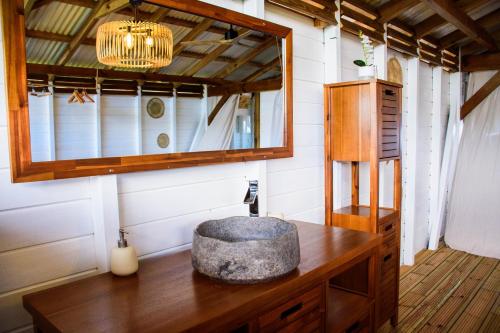 a bathroom with a sink and a mirror on a wooden table at Tootila in Sainte-Rose